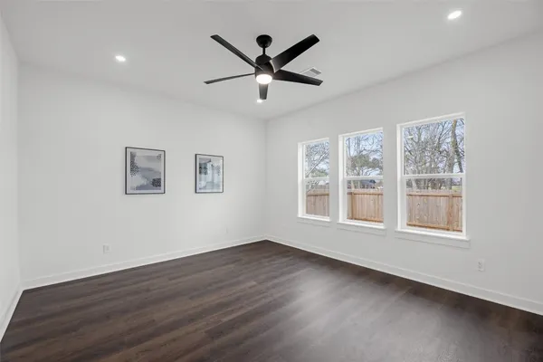 a view of wooden floor and a chandelier fan in a room