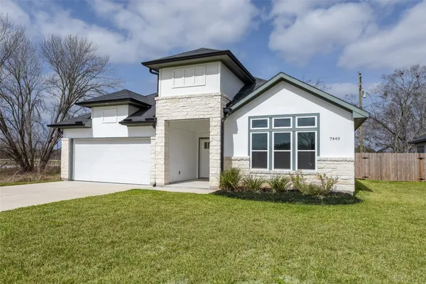 a front view of a house with a yard and garage