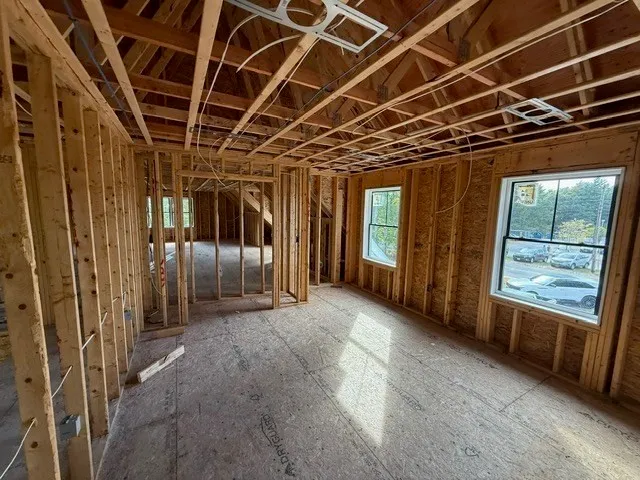 a view of an empty room with a fireplace and a window