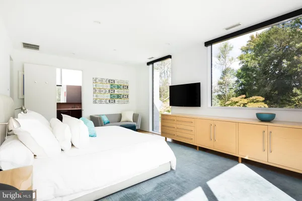 a bedroom with a large bed and a flat tv screen on dresser