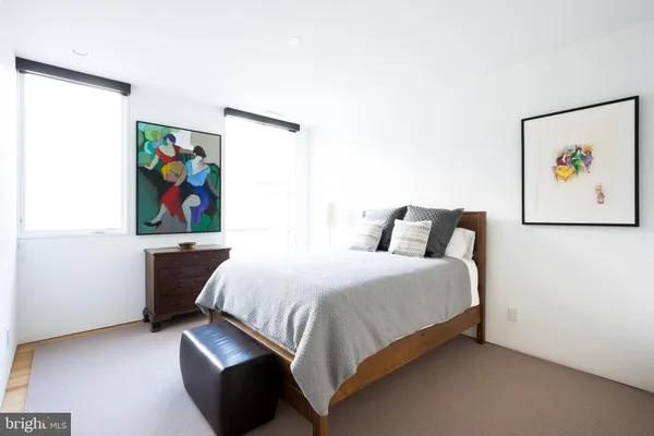 a bedroom with a bed and painting on the wall