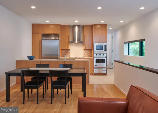 a kitchen with a table chairs refrigerator and microwave