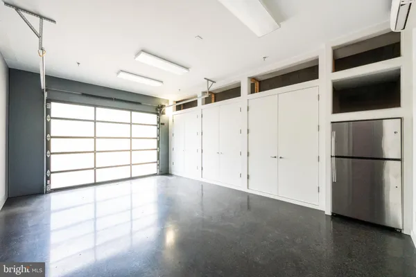 a view of a refrigerator in kitchen and an empty room