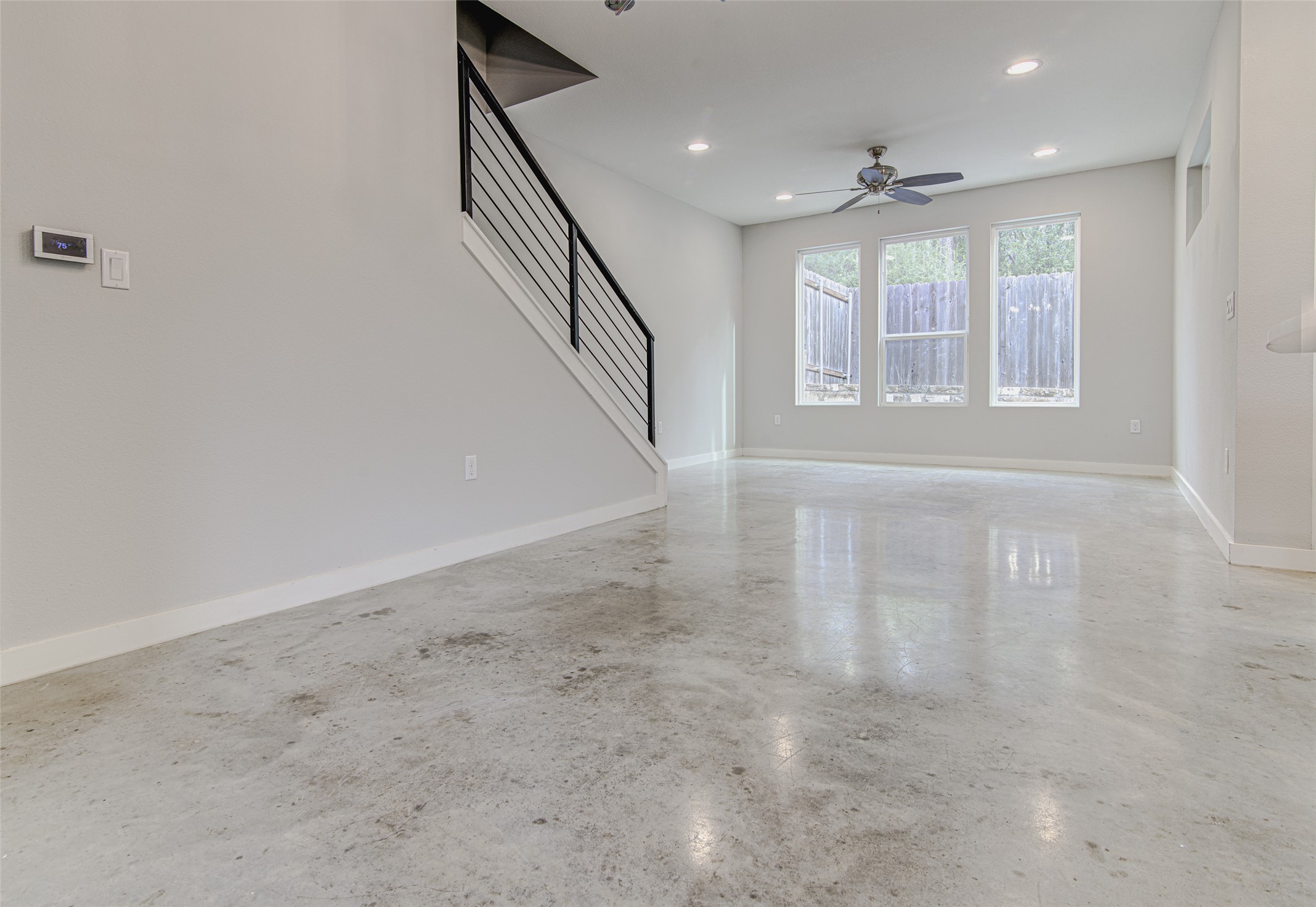 1904 Bunche Road, Unit B Austin, TX 78721 - Photo 9 of 29 Spacious living area with three large windows, a ceiling fan, and plenty of flexibility for living, dining, or working from home.