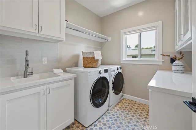 a utility room with sink dryer and washer