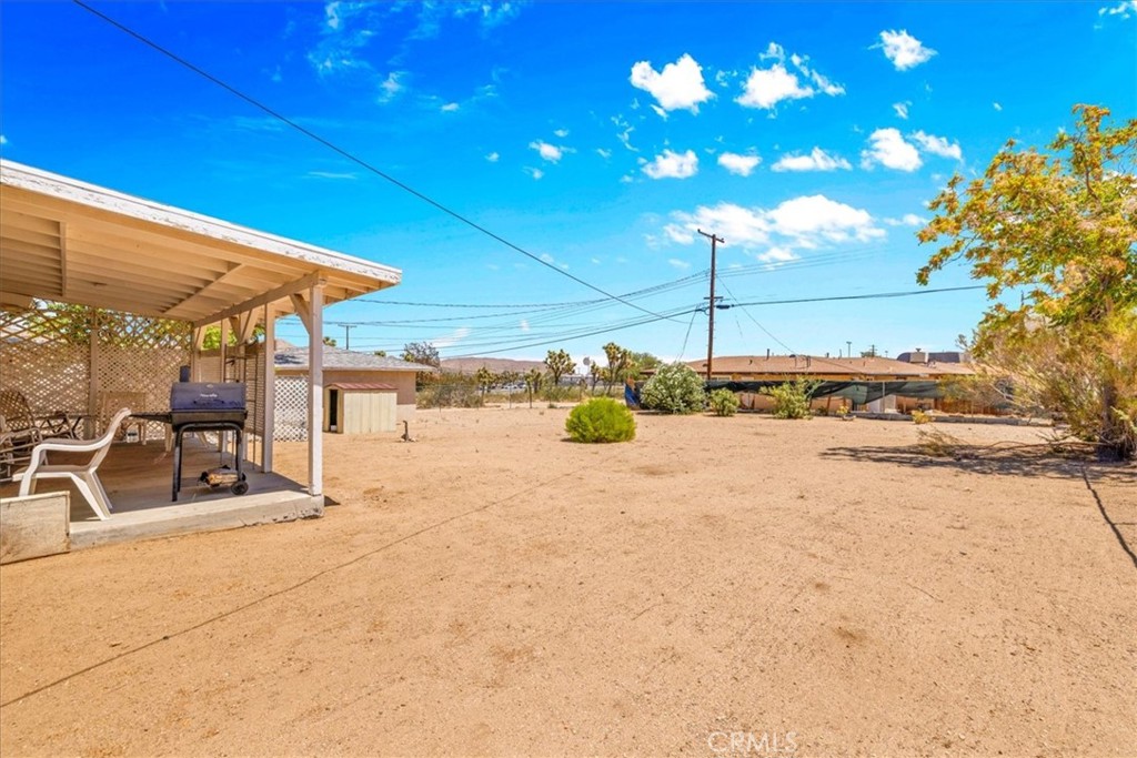 7337 Condalia Avenue Yucca Valley, CA 92284 - Photo 27 of 48 a view of a patio with a table and chairs under an umbrella