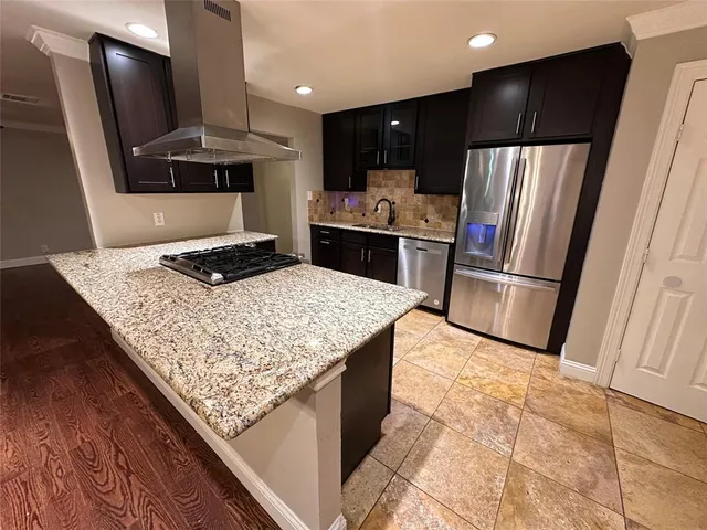 a kitchen with kitchen island granite countertop a stove and a sink