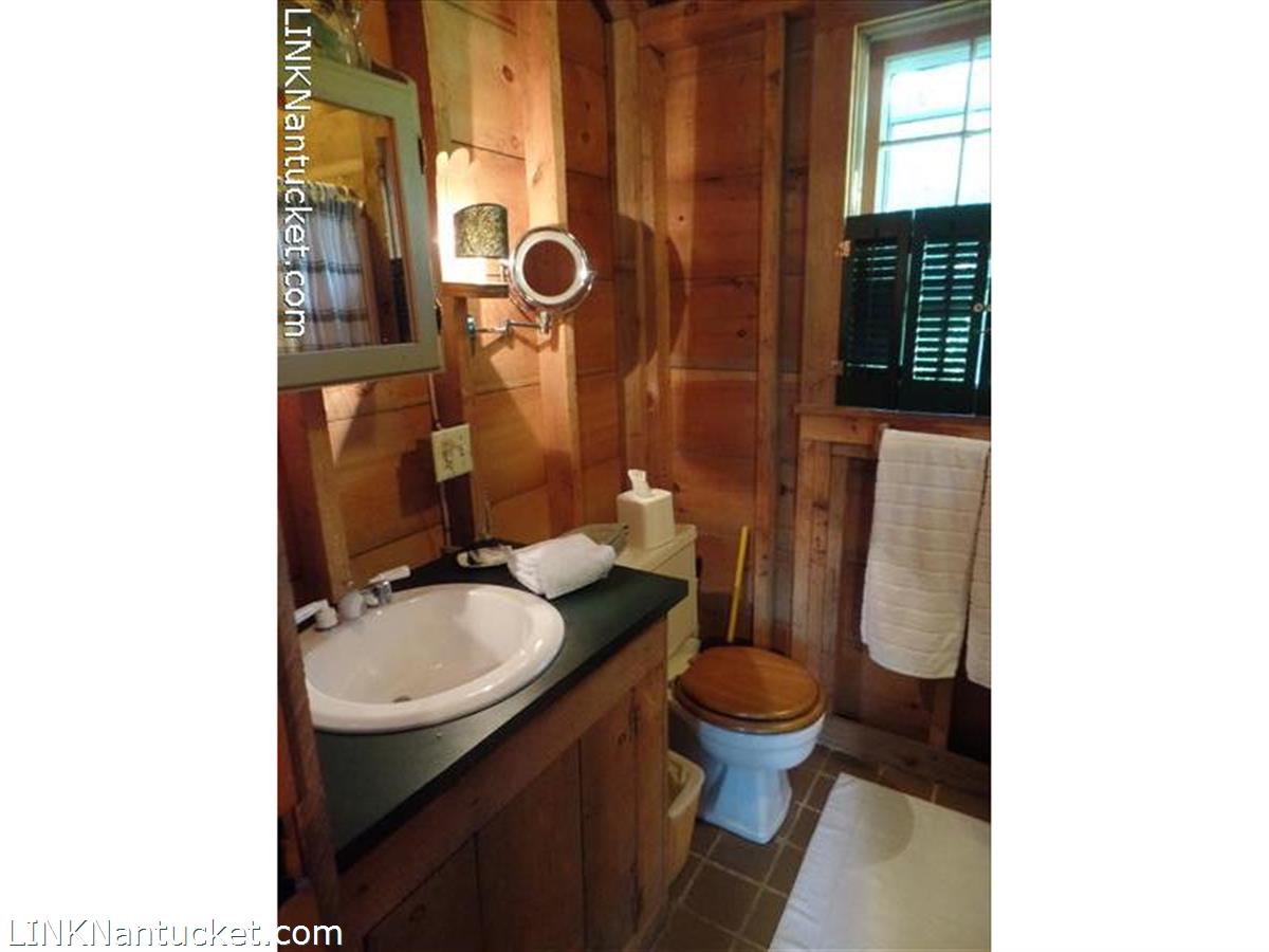 3 West Dover Street Nantucket, MA 02554 - Photo 4 of 4 a bathroom with a granite countertop toilet sink and mirror