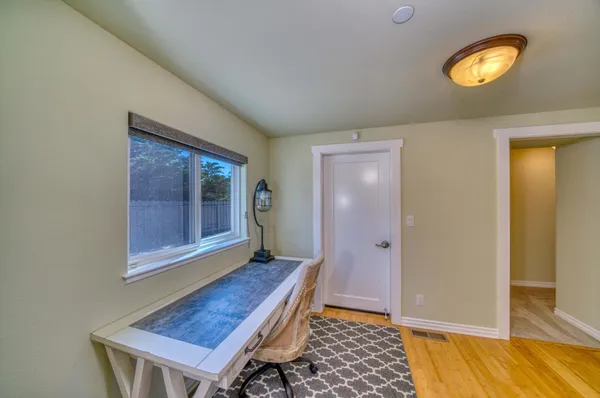 a view of a hallway with wooden floor and a front door