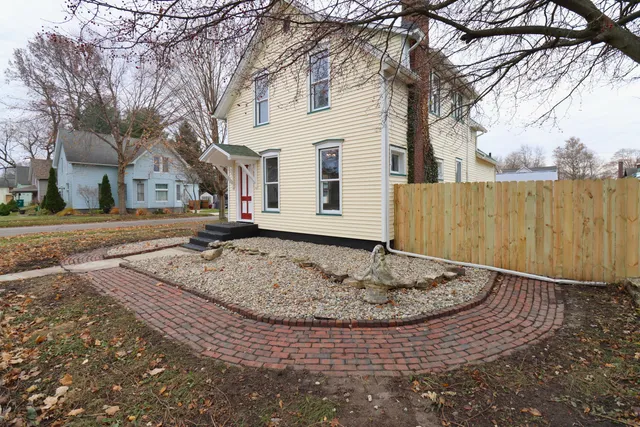 a pathway of a brick house with a yard