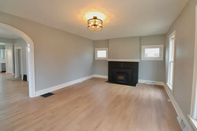 a view of an empty room with a fireplace and a window