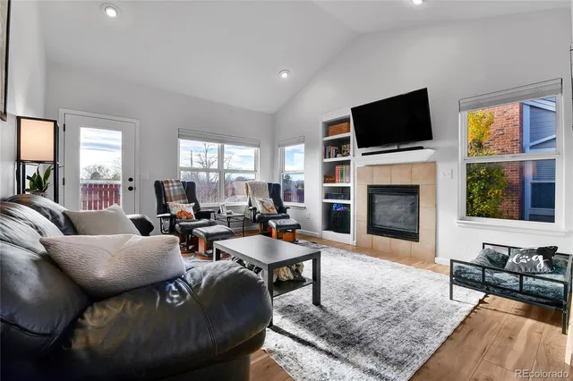 a living room with furniture a fireplace and a flat screen tv