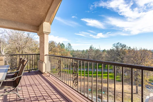 a view of a balcony with wooden floor & fence