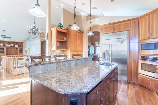 a kitchen with granite countertop a table chairs and wooden floor