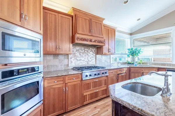 a kitchen with granite countertop a sink and stove
