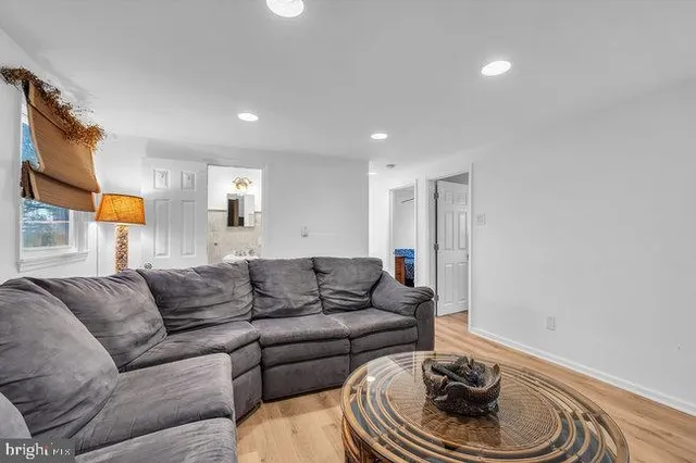 a dining room with wooden floor a chandelier a glass table and chairs