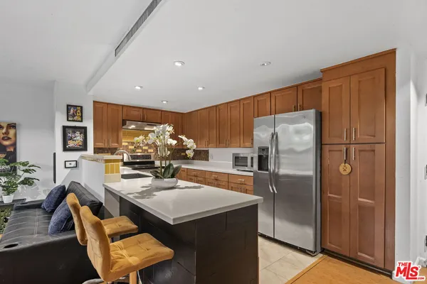 a kitchen with stainless steel appliances granite countertop a refrigerator and a stove