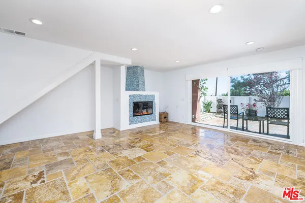 a view of an empty room with a fireplace and a window