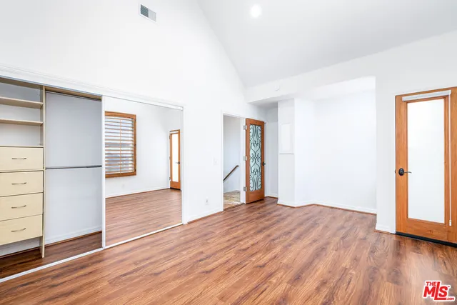 an empty room with wooden floor and closet