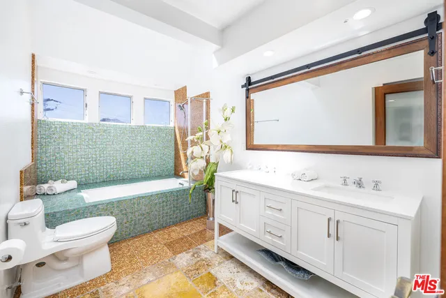 a bathroom with a double vanity sink toilet and shower