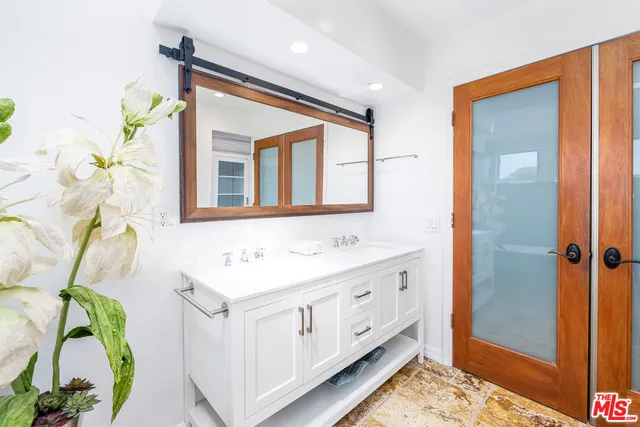 a bathroom with a sink a mirror and a shower