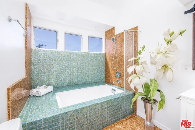 a bathroom with a granite countertop bathtub and a shower
