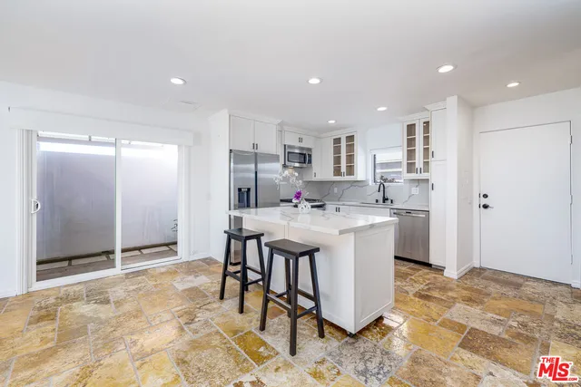 a kitchen with kitchen island a sink appliances and cabinets