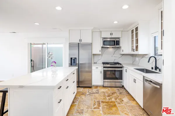a large kitchen with stainless steel appliances granite countertop a stove and a sink