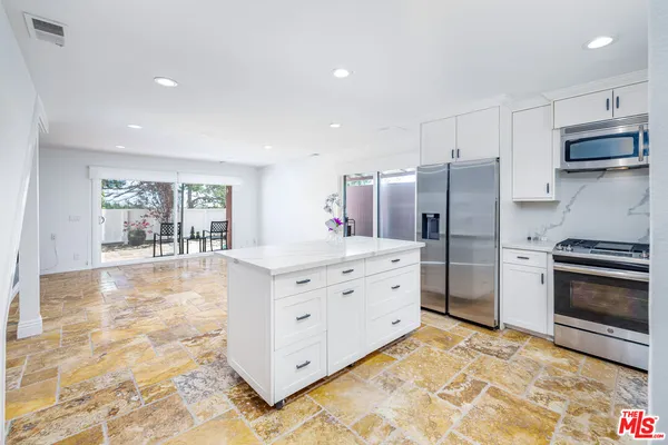 a kitchen with stainless steel appliances a refrigerator sink and stove