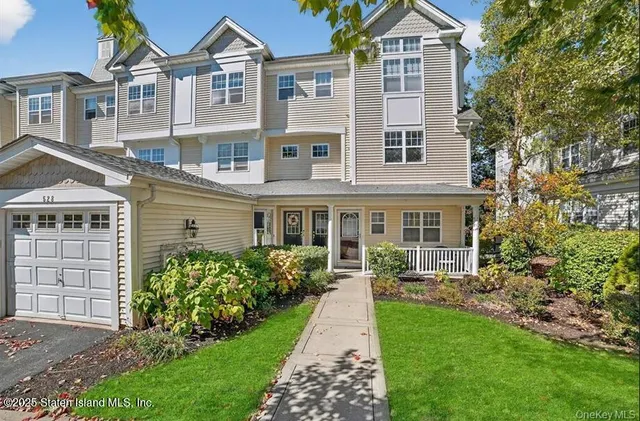 a front view of a house with a yard and potted plants