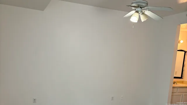 a fan in a room next to a window