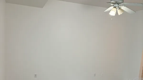 a view of a room with a chandelier fan