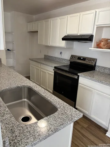 a kitchen with a sink stove and cabinets