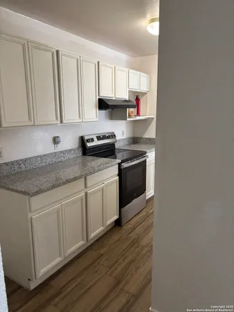 a kitchen with granite countertop white cabinets and a sink