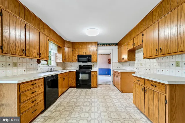 a kitchen with stainless steel appliances granite countertop wooden cabinets a stove top oven a sink and dishwasher