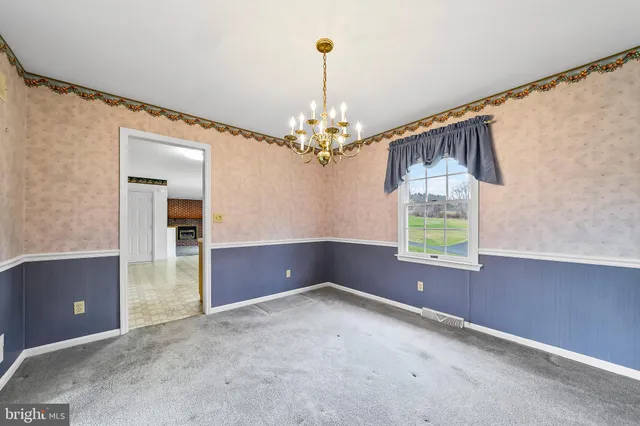 an empty room with windows and chandelier