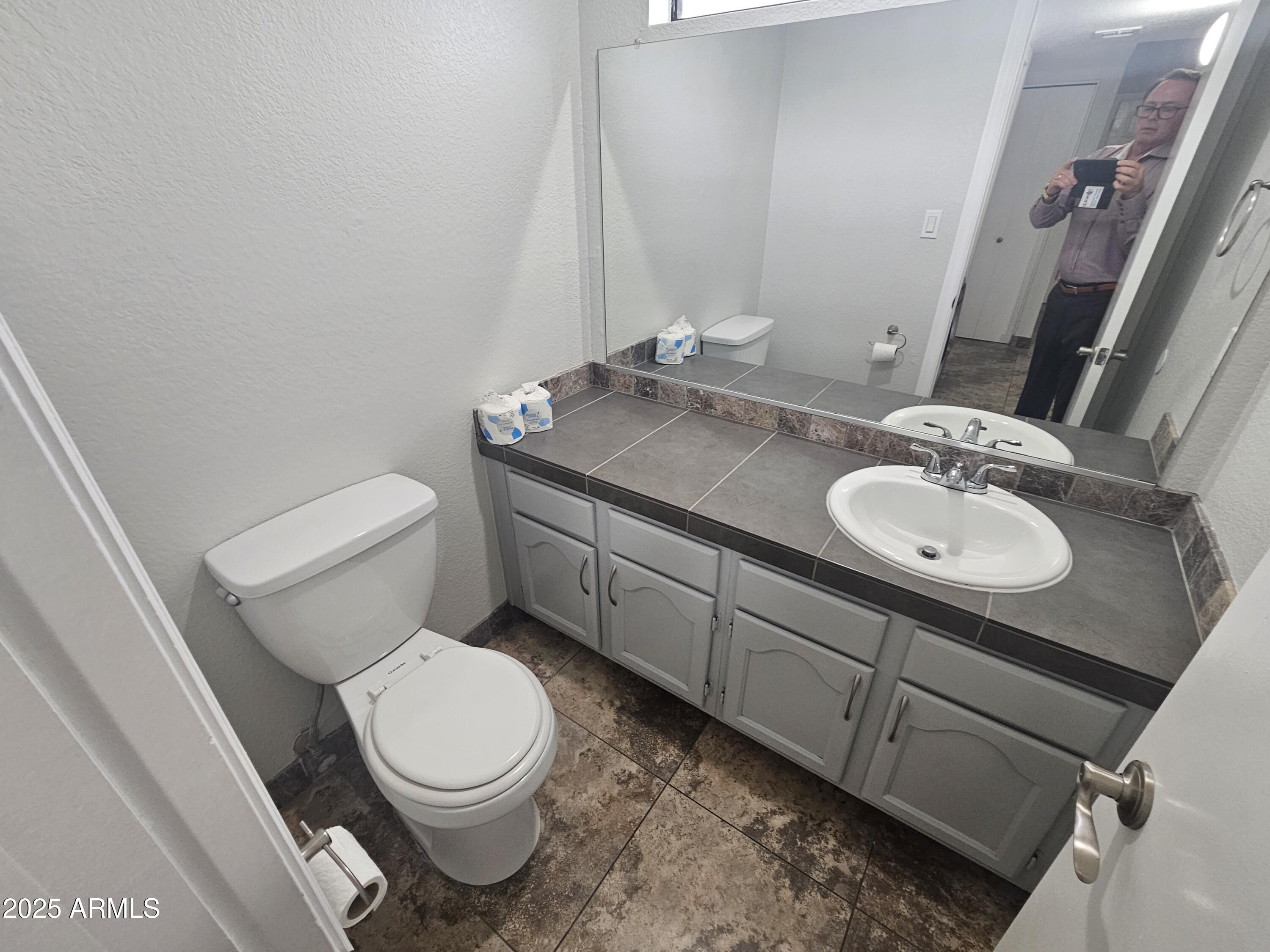 10032 West Sells Drive Phoenix, AZ 85037 - Photo 13 of 19 a white toilet sitting next to a bathroom sink