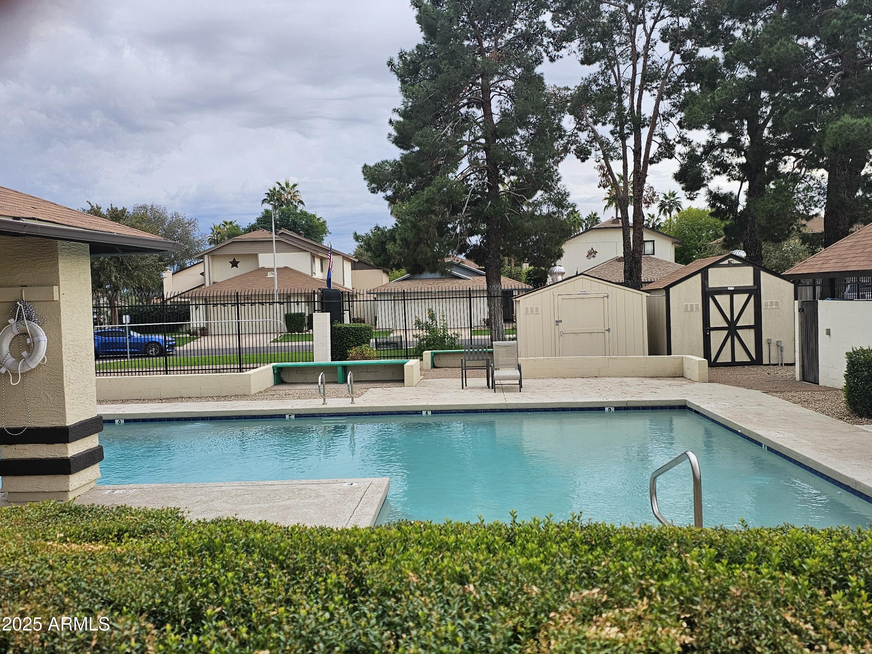 10032 West Sells Drive Phoenix, AZ 85037 - Photo 18 of 19 a view of a swimming pool with outdoor seating and a garden
