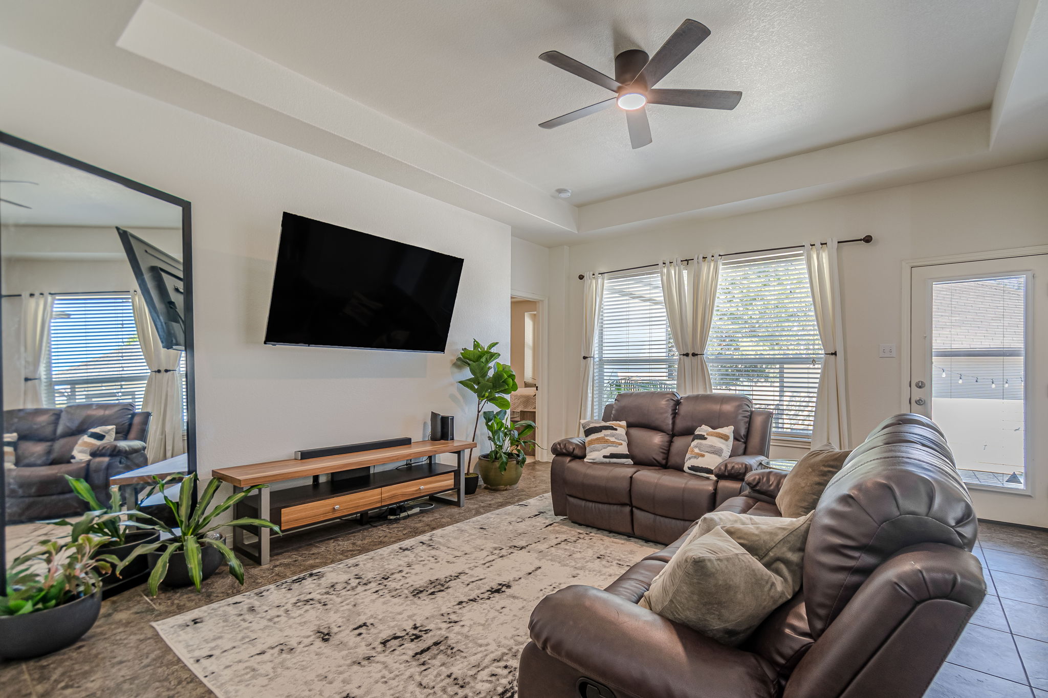 1031 Powell Kyle, TX 78640 - Photo 12 of 40 Living room featuring a raised ceiling, a ceiling fan, and plenty of natural light