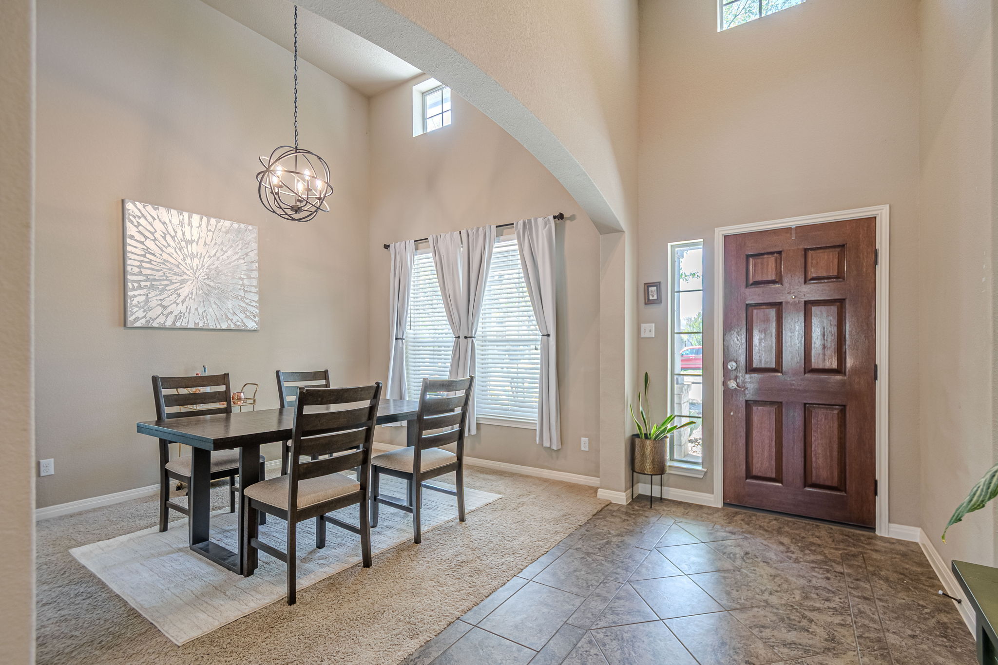 1031 Powell Kyle, TX 78640 - Photo 4 of 40 Dining area with hanging lights, light tile patterned flooring, a high ceiling, and arched walkways
