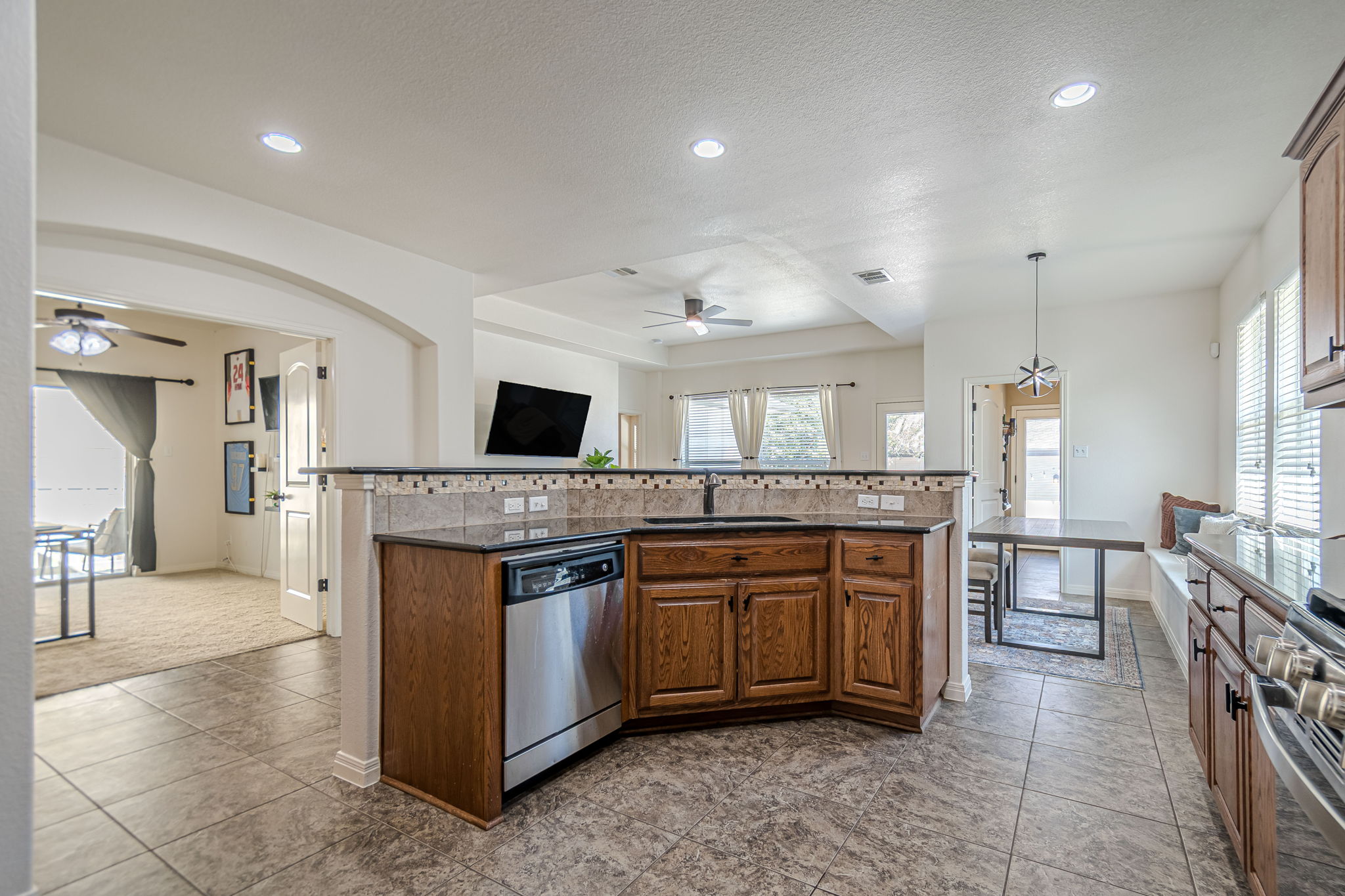 1031 Powell Kyle, TX 78640 - Photo 7 of 40 Kitchen with wood cabinetry, stainless steel appliances, and a textured ceiling