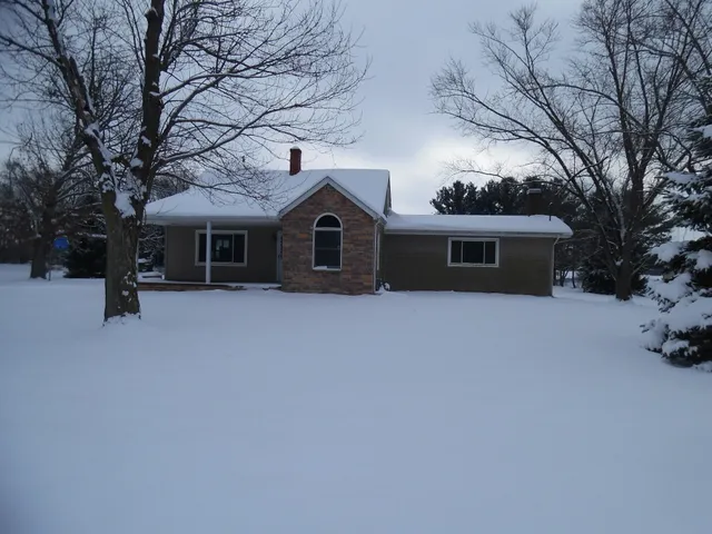 a front view of house with yard and trees in the background
