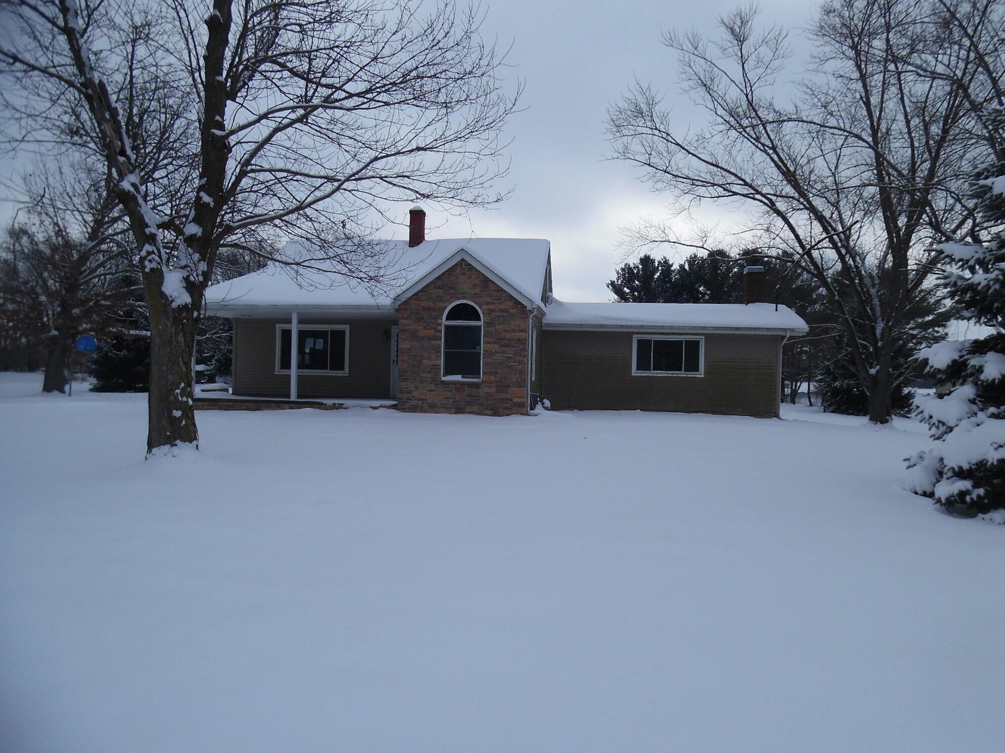 a front view of house with yard and trees in the background