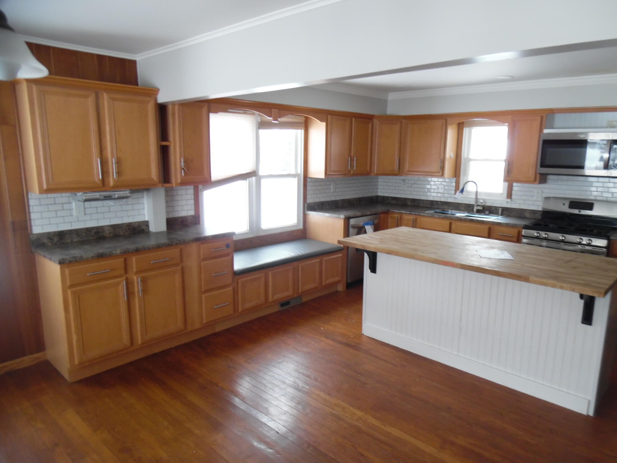 813 West Division Road De Motte, IN 46310 - Photo 7 of 20 a kitchen with wooden floors and sink