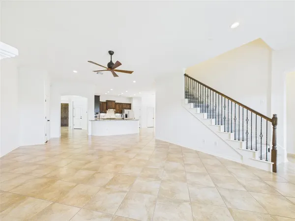 wooden floor in a hall with a window and a ceiling fan