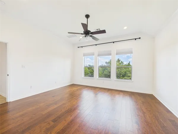 a view of room with wooden floor and fan