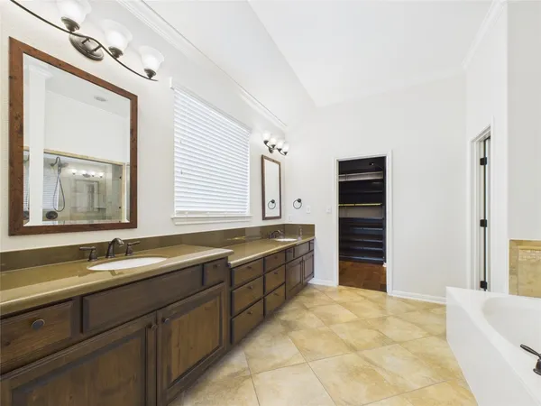 a bathroom with a tub sink and mirror