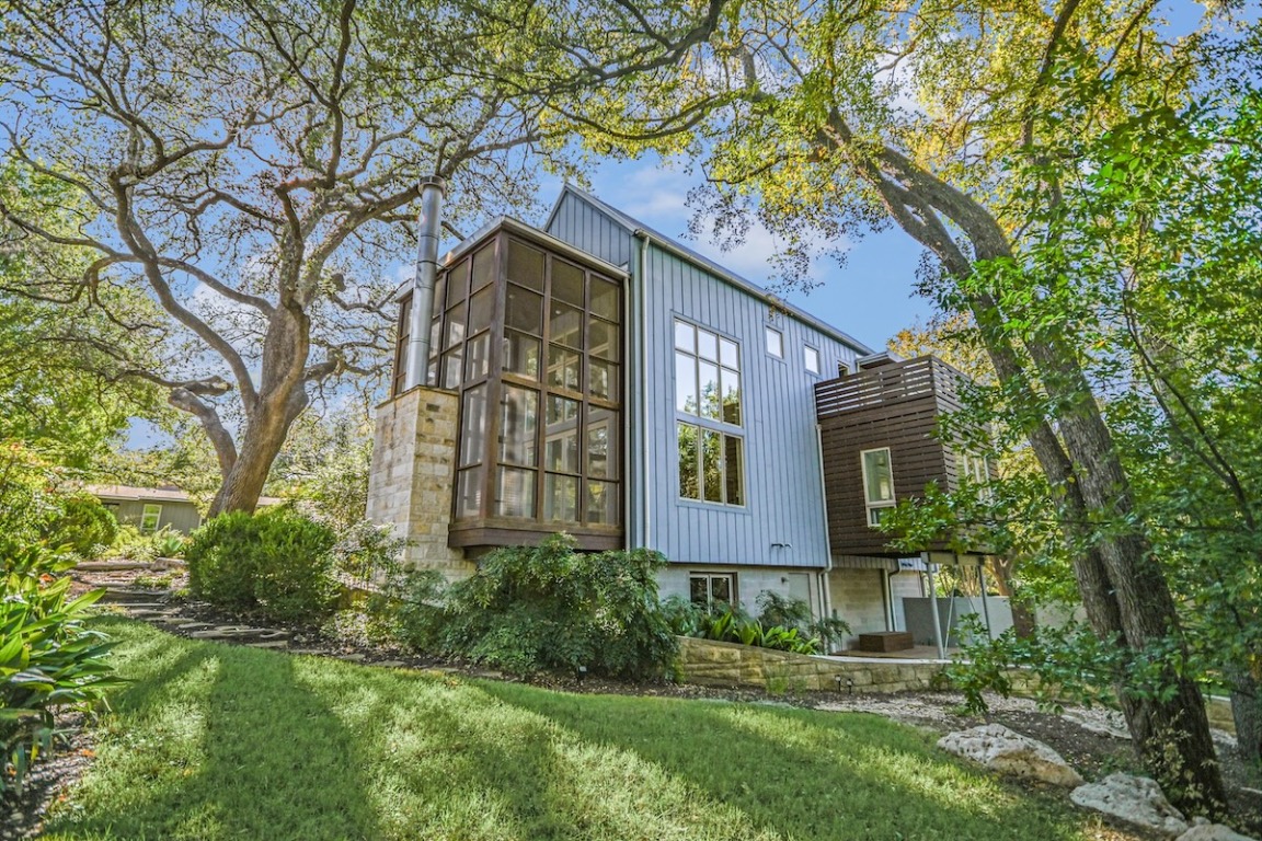View of property exterior with board and batten siding and a lawn