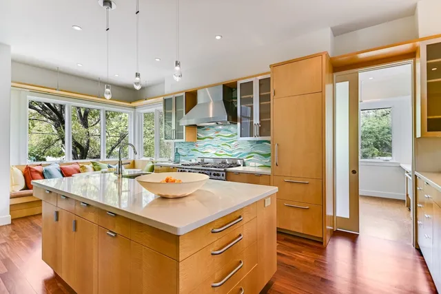 a dining hall with stainless steel appliances granite countertop a sink and a large window with wooden floor