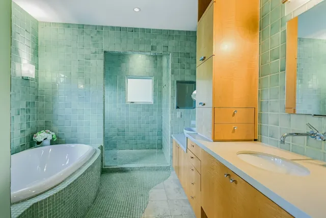 a bathroom with a granite countertop bathtub shower sink vanity and mirror